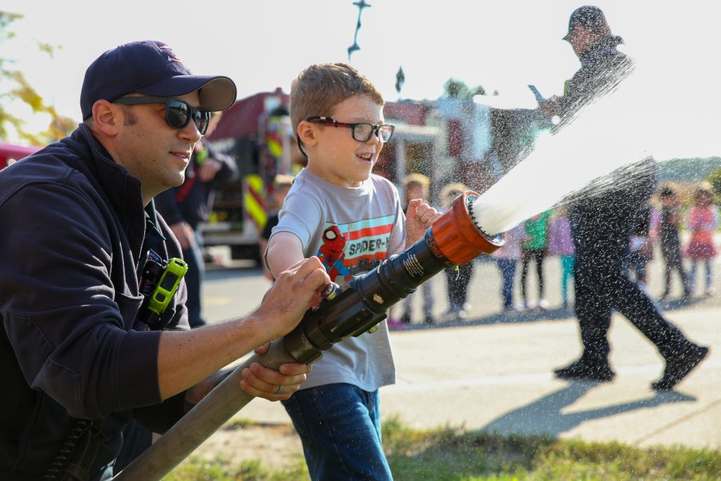 Firefighter operates hose