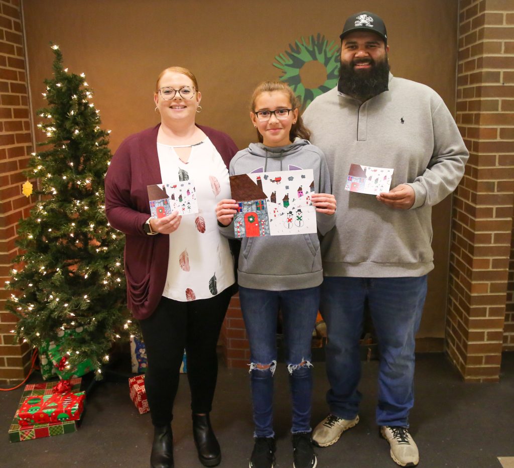 Holiday card winner holding card with parents