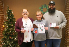 Holiday card winner holding card with parents