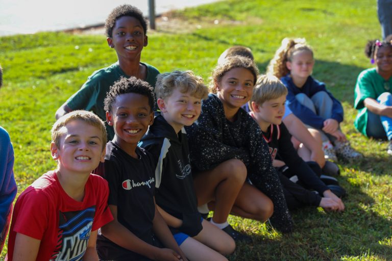 Group of children posing for a picture in an outdoor setting.