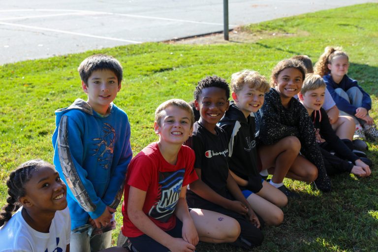 Group of children posing for a picture in a park.