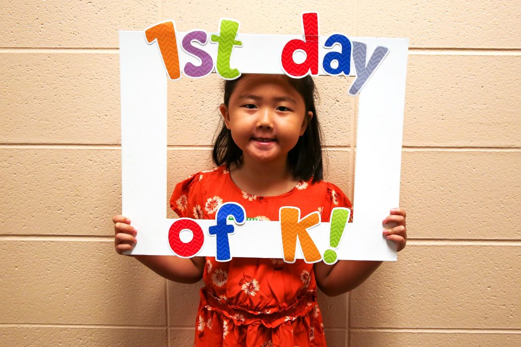 Student holding sign that says 1st day of K!