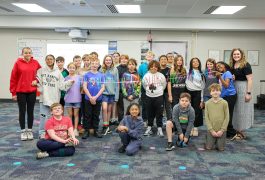 Students posing in a classroom for a group picture.