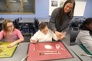 Josie Engdahl helping her students with a clay lesson