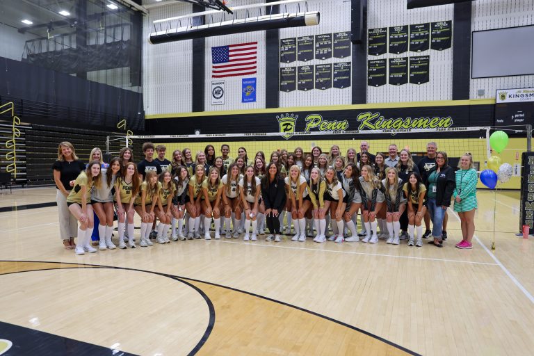 A group of cheerleaders posing for a picture on a basketball court.